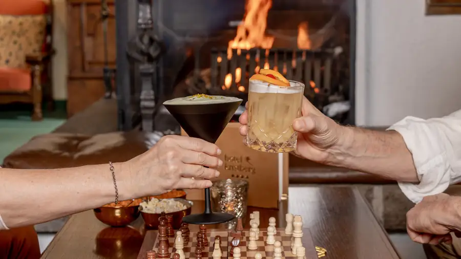 Zwei Cocktails über einem Schachbrett vor dem Kamin