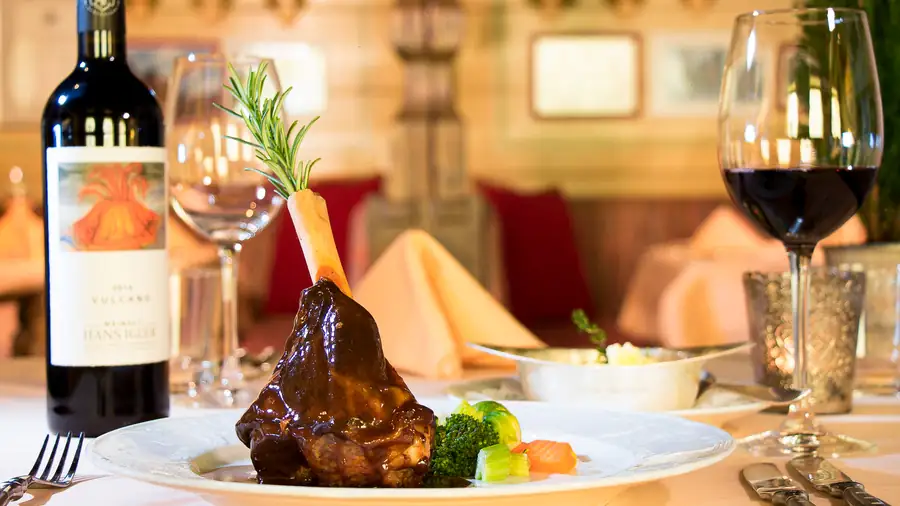Glasierte Schweinshaxe mit Rotwein, abendliches Stillleben