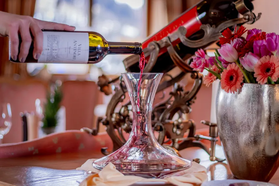 Rotwein fließt in eine Kristallkaraffe
