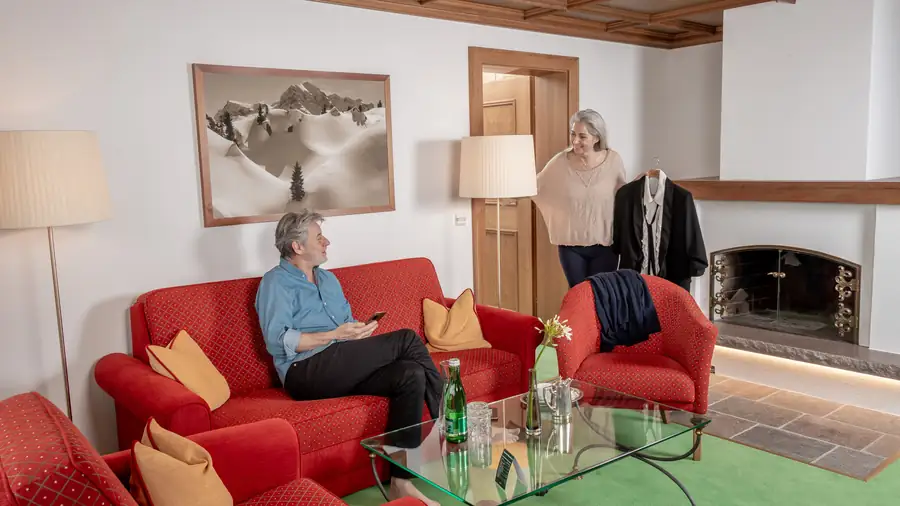 Wohnbereich einer Suite mit offenem Kamin und roten Sesseln